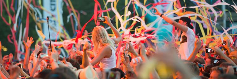 crowd at a music festival with streamers flying through air
