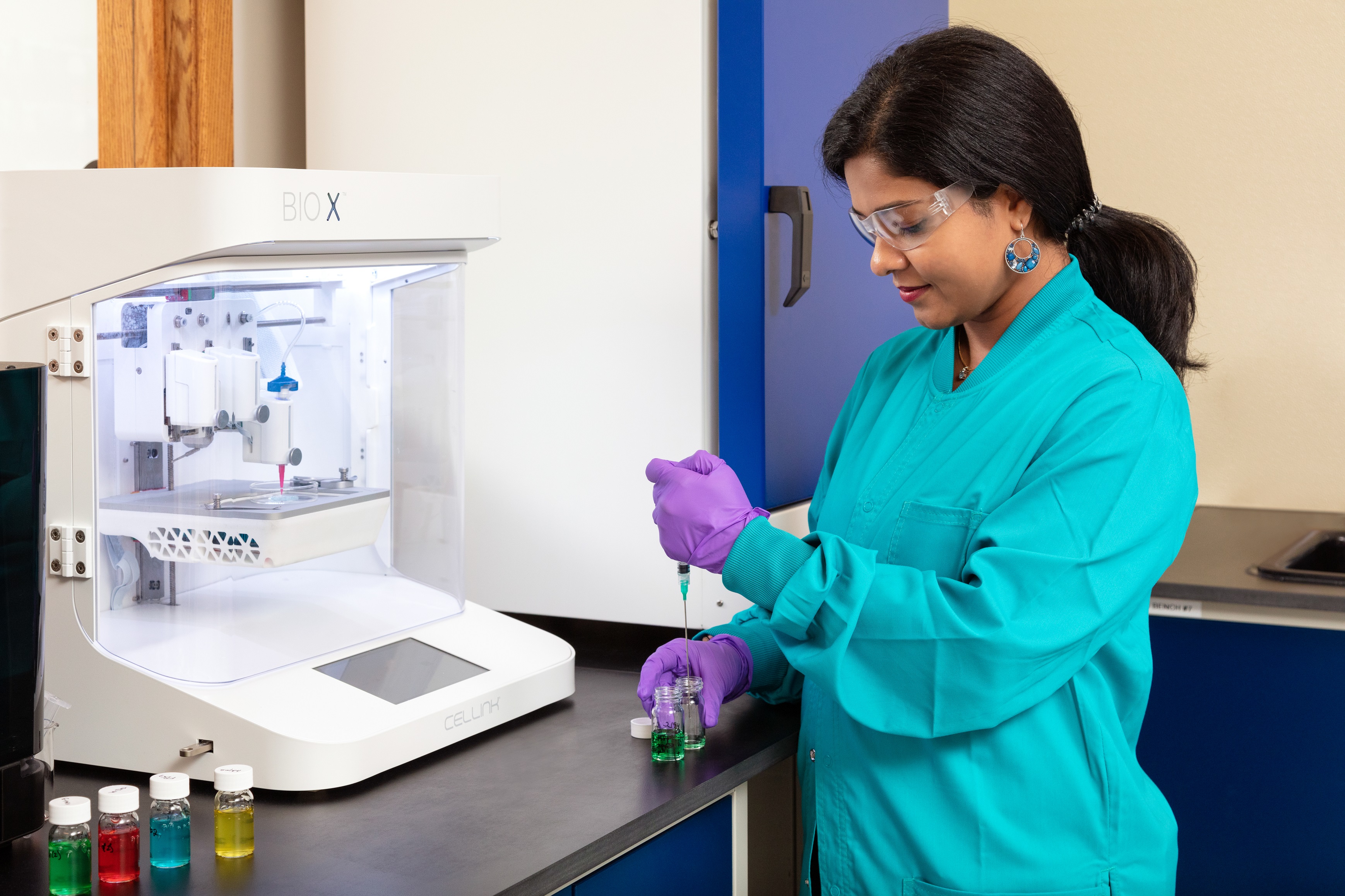 Photo of an employee working with laboratory equipment at CaliberMRI.