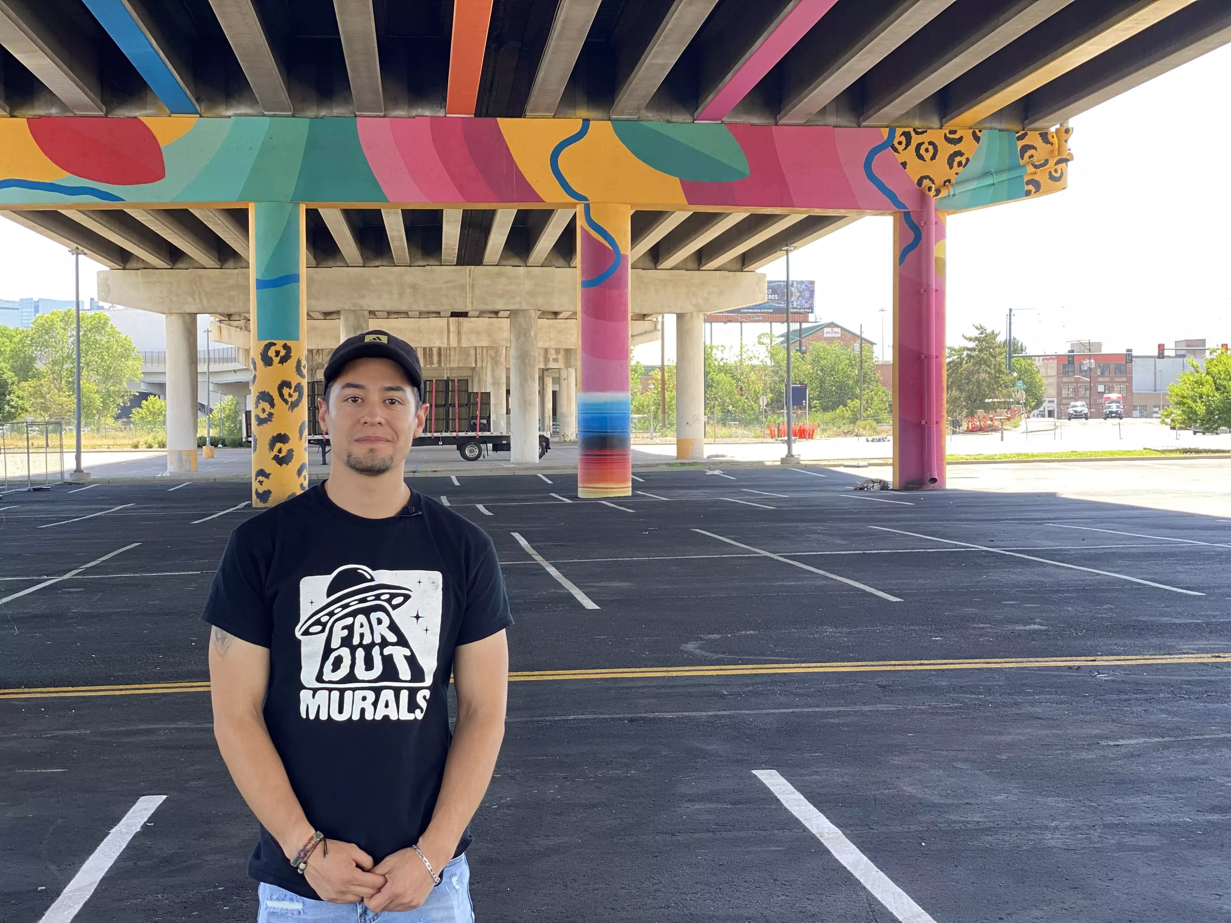 Muralist Julio Mendoza stands beneath the ural he painted under the Colfax Viaduct in Denver.