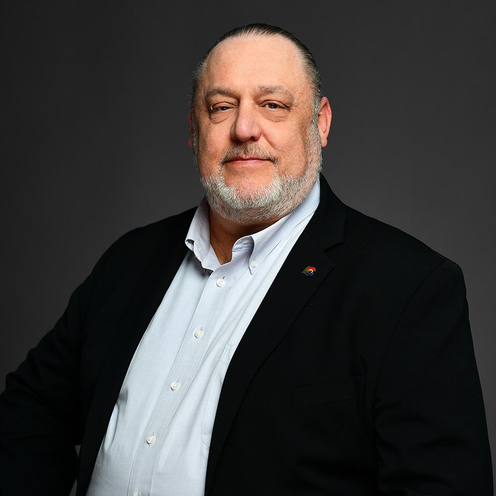 A handsome, older gentleman with a thin, graying beard and wearing a black suit