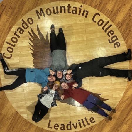 The CMC Wright Collegiate Challenge team lies on top of their school logo.