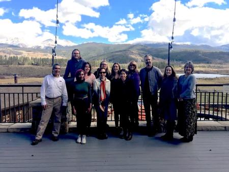 12 change leaders pose on a porch with mountain vista behind them