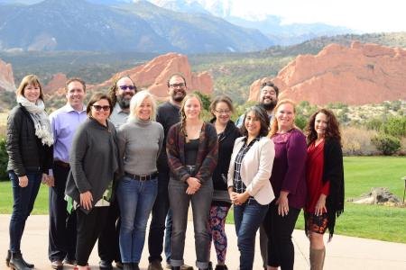 12 change leaders pose in a cluster in front of red rocks