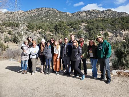 14 change leaders pose on a gravel path. Behind them is a river and brush-covered hills.