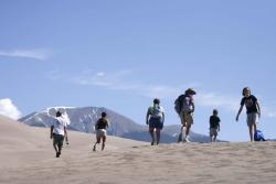 A group of people walking on the Great Sand Dunes, Alamosa County