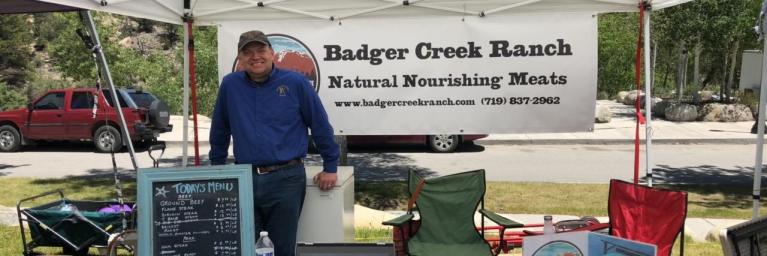 Man in front of Badger Creek poster