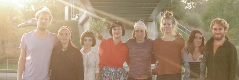 eight people standing together under bridge