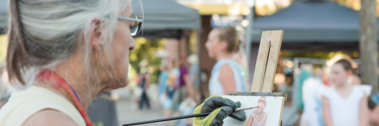 Female artist painting at Longmont, Colorado Art Walk