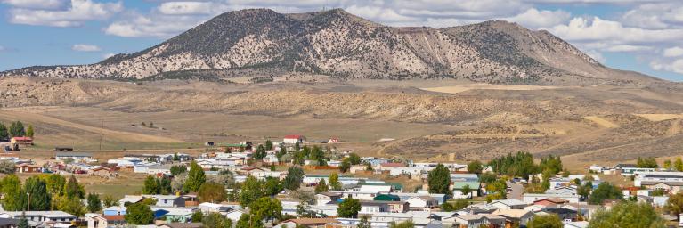 An aerial view of a Colorado town called Craig in front of a mountain and under a blue sky with clouds.
