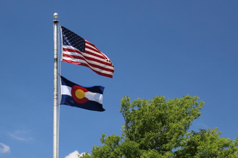 American flag waves above the Colorado flag