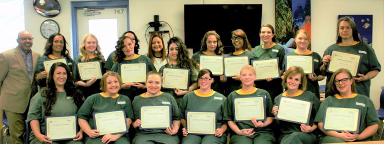 Recently incarcerated women smile as they receive a certificate for a fresh start