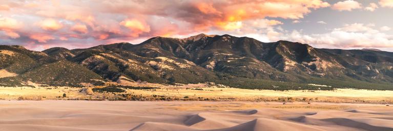A sunset photo of the Great Sand Dunes in Alamosa County