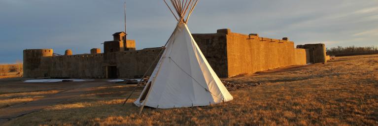 Bent's Old Fort with a tipi outside of it. 