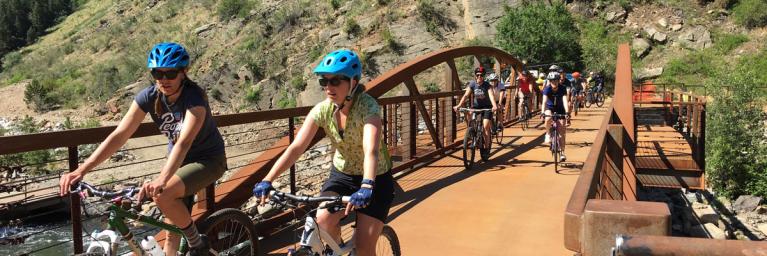 People biking over bridge in Colorado