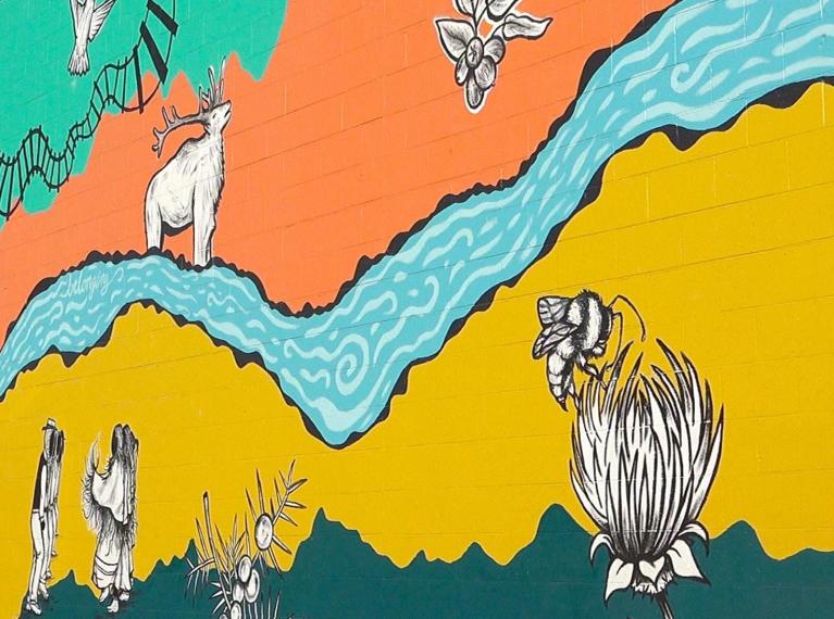 Colorful mural of animals and a stream on a building wall