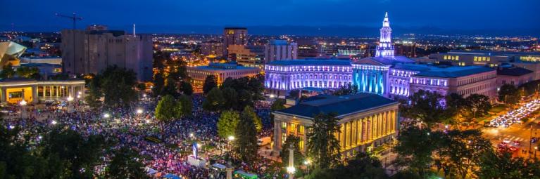 The Denver City & County building glows blue as a crowd gathers for Independence Day celebrations.