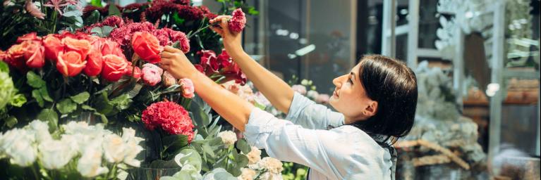 woman pulls a flower from a bunch