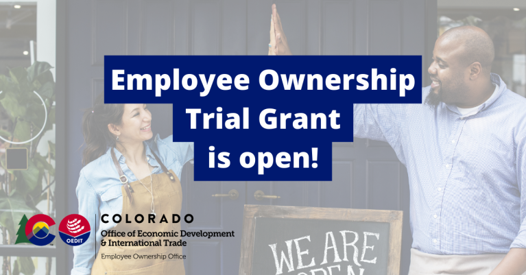 Two people high five in front of shop with text saying employee ownership trial grant is open