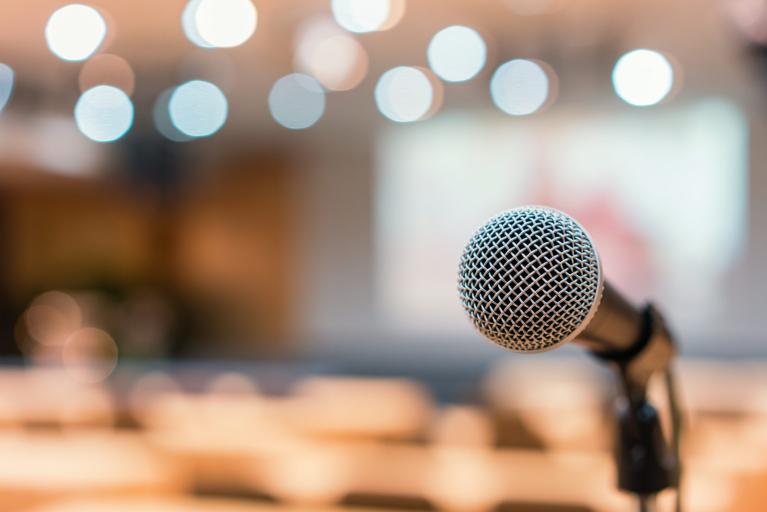 Microphone in focus with audience in the back round