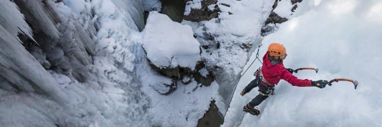 Person climbing ice with climbing gear