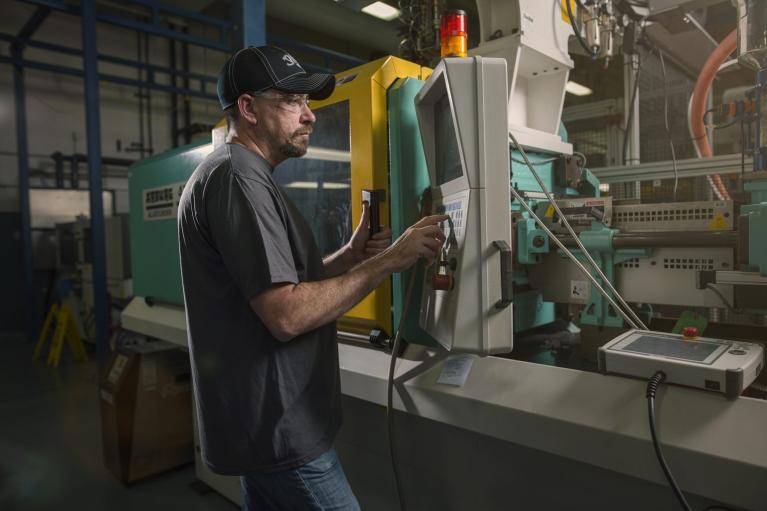 man working with machine in factory