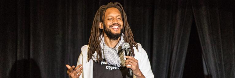 man laughing while holding microphone