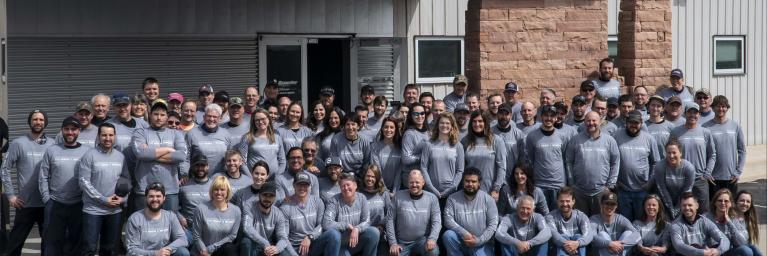 Staff members gather for a photo outside Stone Age building.