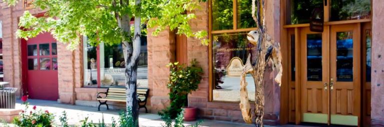 Streetscape in the town of Lyons featuring business fronts and a sidewalk