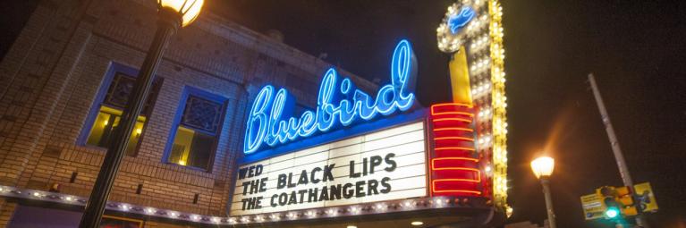 Bluebird theater sign with people out front of venue at night