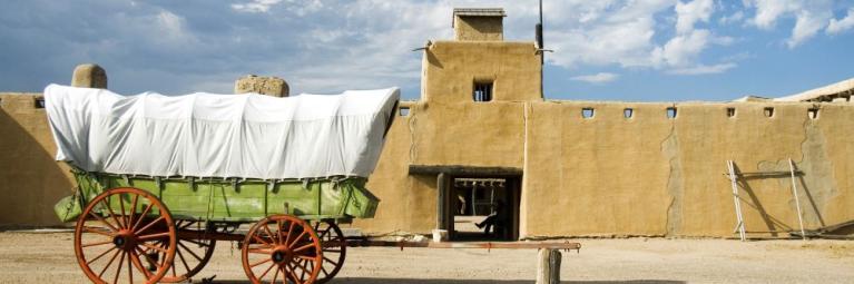 A covered wagon sits in front of a historic fort in La Junta.