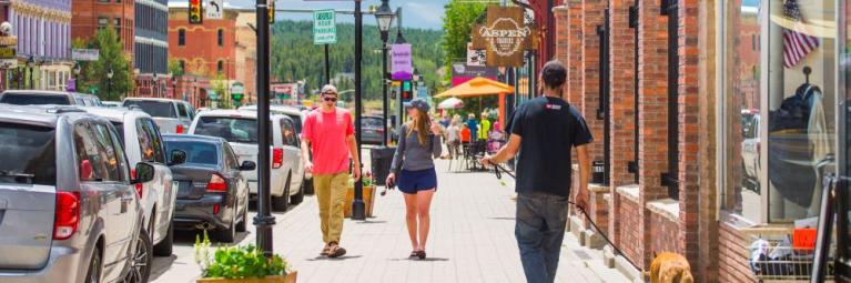 People walking down a street in downtown Leadville on a sunny day.