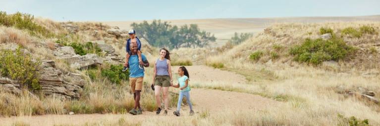 A family of four hikes a path in Yuma County on a sunny day.