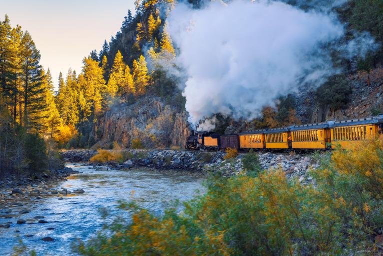The famous train in Durango next to the river and fall colors