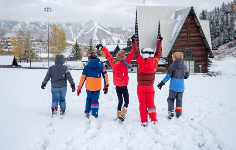 Children wearing Town Hall Outdoor Co. suits outside in the snow