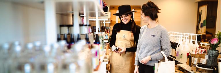 small business owner and patron stand in store