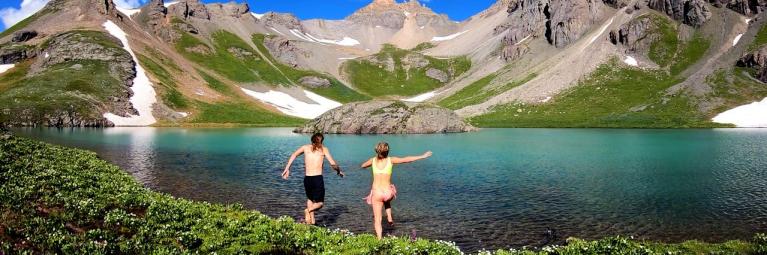 two people running into island lake outside of silverton, colorado