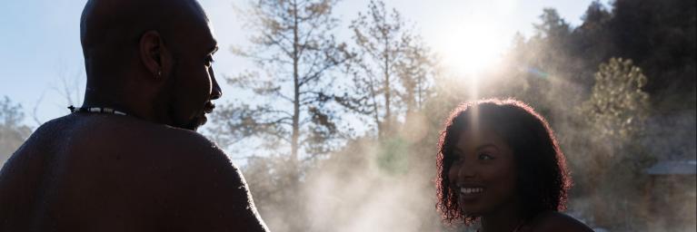 Two people talking while sitting in hot springs