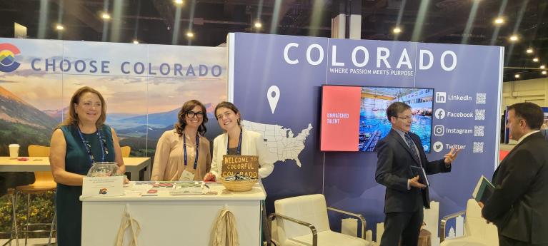 OEDIT staff and regional economic development in front of a booth at SelectUSA