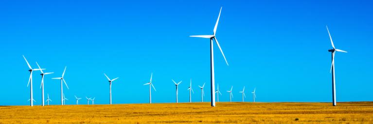 Windmill farm on plains with blue sky