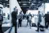 Black and white photo of blurred people walking through a trade show