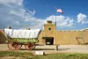 A covered wagon sits in front of a historic fort in La Junta.