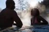 Two people talking while sitting in hot springs