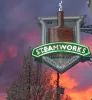 steamworks business sign in front of sunset background